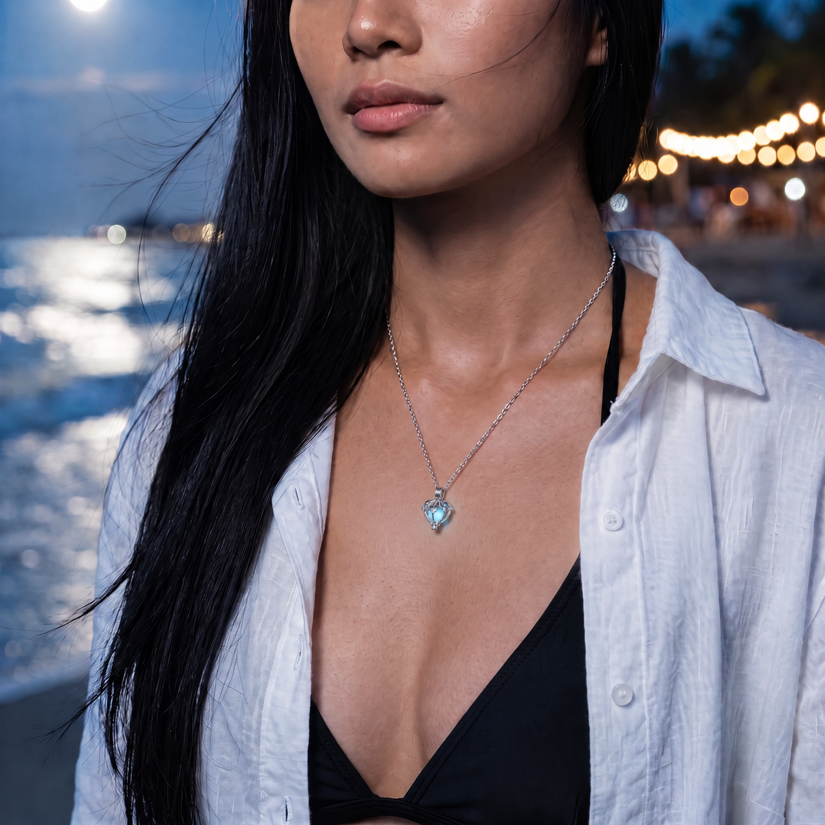 Luminous Dolphin Necklace worn at night. Moonlit beach.