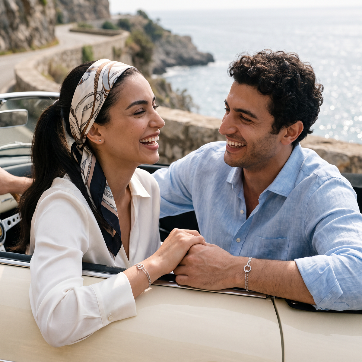 Aureole Double Ring & Heart Bracelets worn by a couple in a vintage convertible on the coast