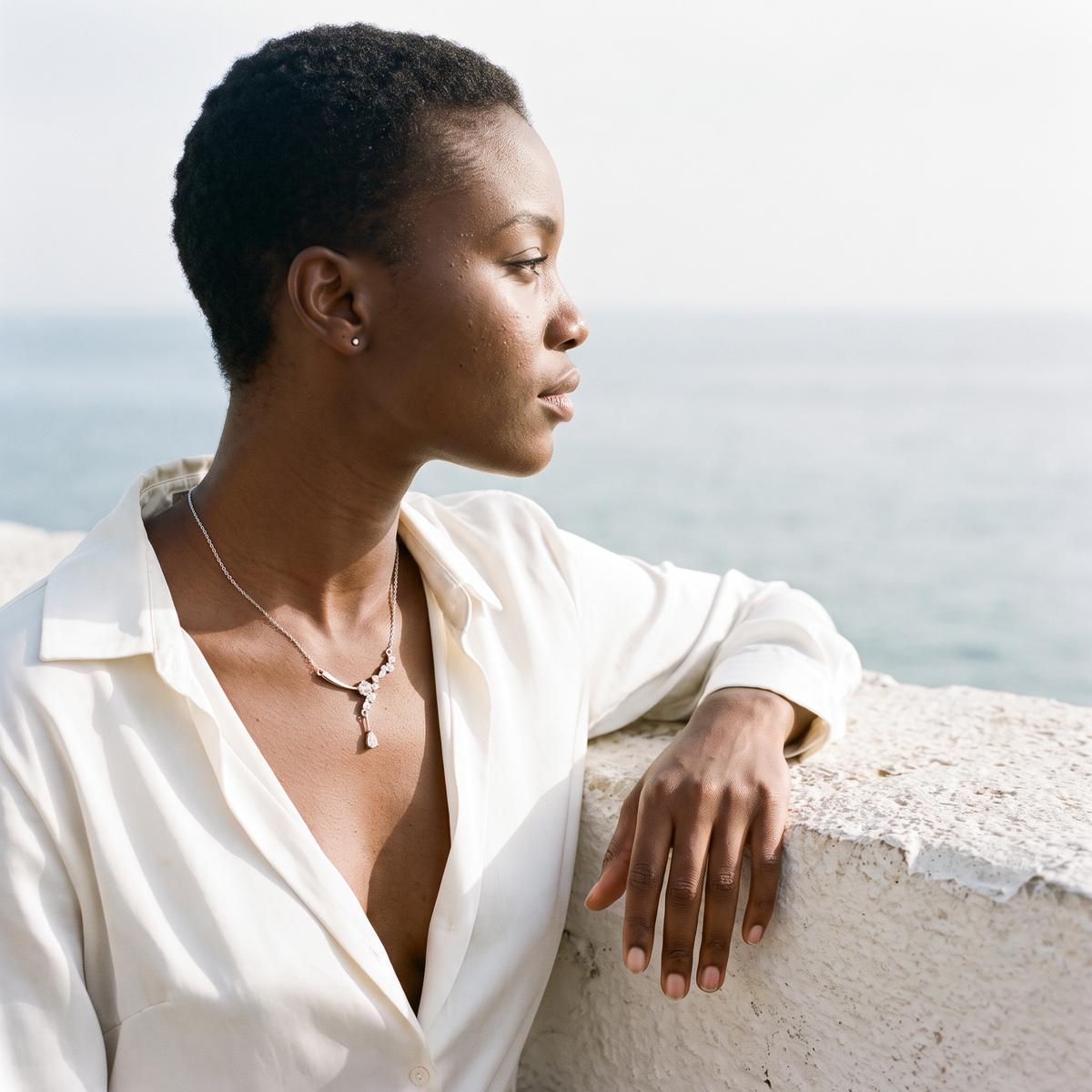 Aureole Moissanite Celestia Necklace worn on a seaside terrace in the morning